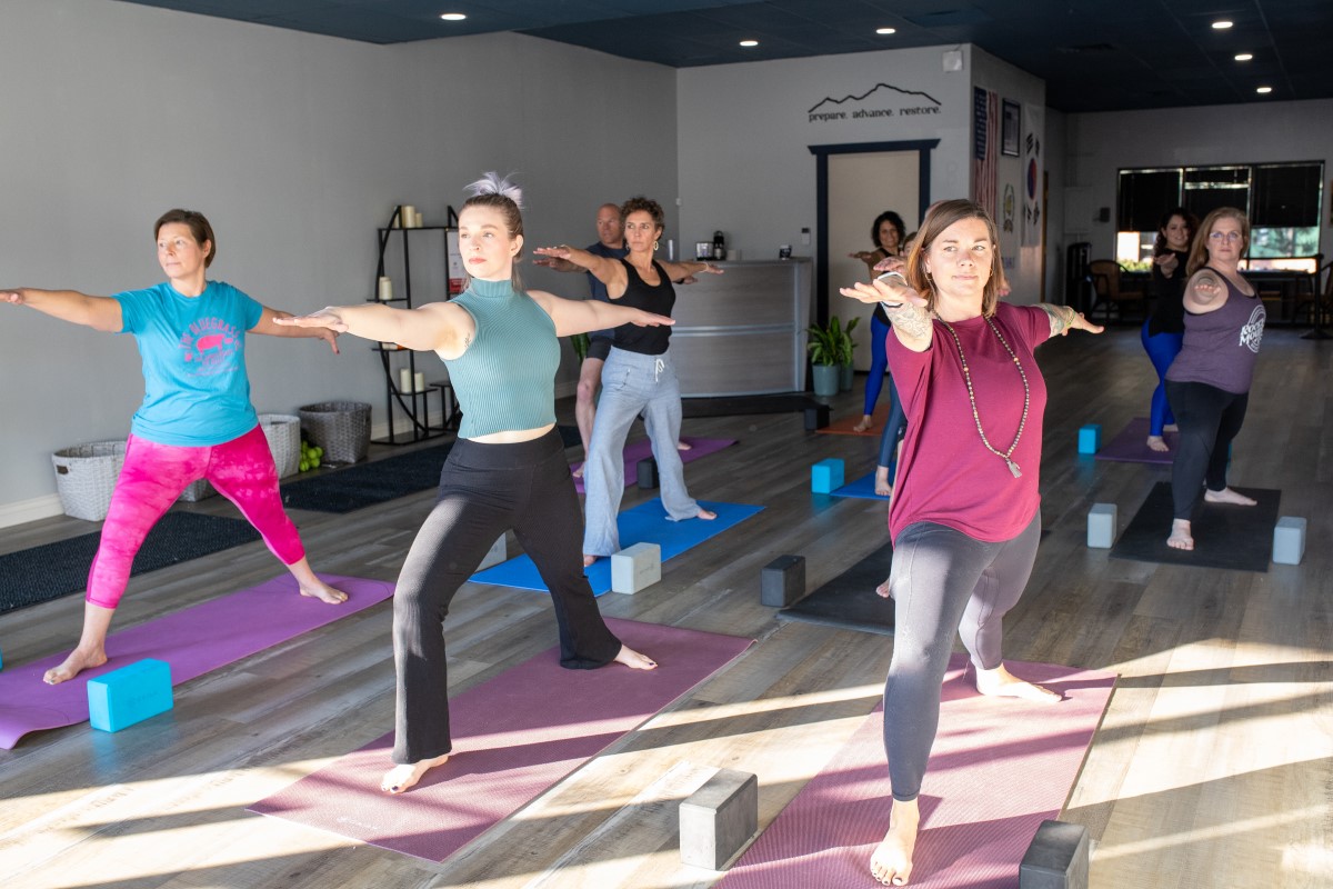 A diverse group of people taking a yoga class.